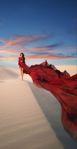Dancing with the Elements: A Symphony of Color and Fabric in a Sandy Landscape