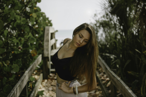 Elegant Woman in Black Top Exploring a Tranquil Beach Pathway