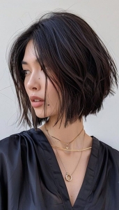 Intriguing Portrait: Dark-Haired Individual in a Black Top with Layered Necklaces