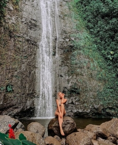 Nature's Fashion Runway: A Model Amidst Waterfall Scenery