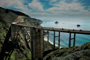 Skyward View from Airplane Wing Over Scenic Coastal Bridge